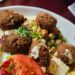 a white plate topped with meatballs and a salad