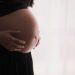 pregnant woman cradling her belly