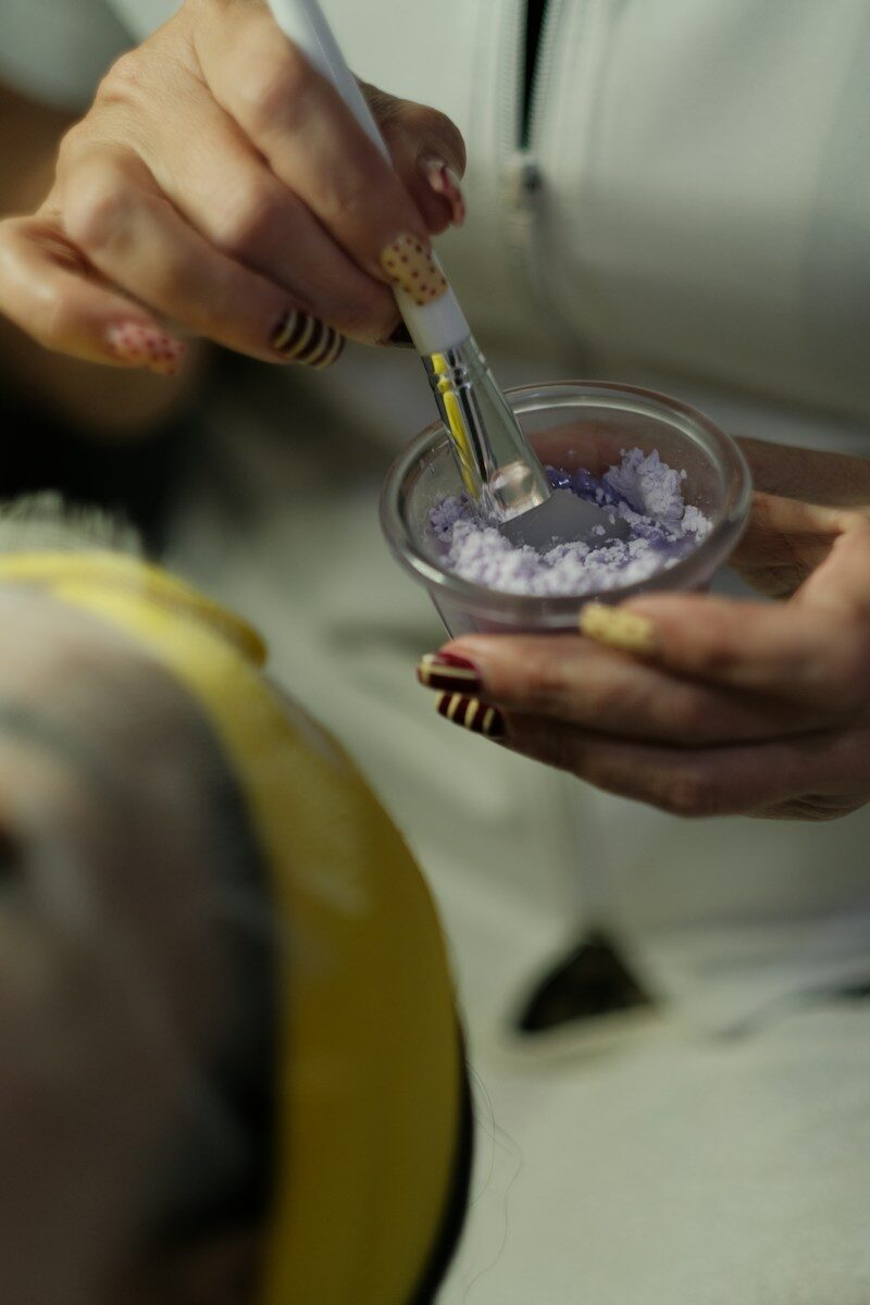 The Business Side of Becoming a Freelance Beauty Professional 1 Hands preparing a purple cosmetic mask with a brush